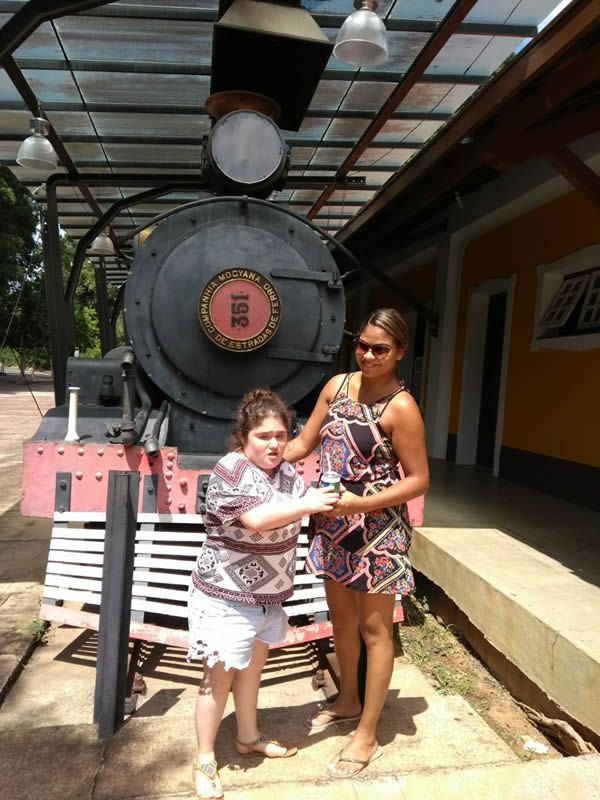 Marcela e Priscila em frente à uma locomotiva de trem